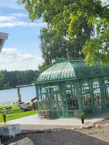 un gazebo verde seduto accanto a un lago di Stuga Ani a Svartå