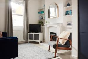 sala de estar con chimenea y silla en 13 Oxford Street en Exeter