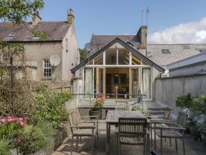 a patio with a table and chairs in front of a house at The River House in Ramelton