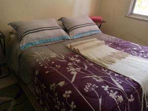 uma cama com um cobertor roxo e almofadas em Nueve Lunas em Temuco