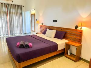 um quarto com uma cama com dois pares de sapatos em Tropical Villa - Weligama em Weligama