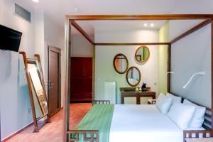 a bedroom with a white bed and a mirror at Splanzia Boutique Hotel in Chania