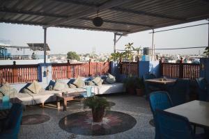 a patio with couches and tables on a roof at Pushp Guest House in Jodhpur