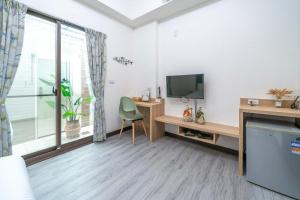 a room with a television and a desk with a chair at Park Oasis in Tainan
