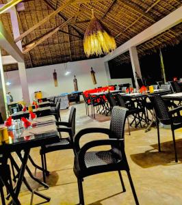 a dining room with tables and chairs in a restaurant at MAISON CARREE in Andilana