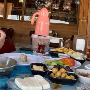 a table with plates of food and a pink bottle at Nur Konak Bungalov 7 in Çanakkale