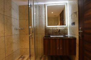 a bathroom with a sink and a shower with a mirror at Mastiff Hotel Dhanbad in Dhanbād