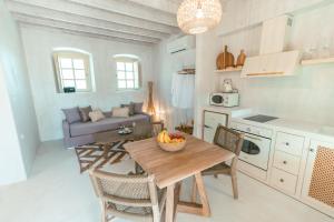 a kitchen and living room with a table and a couch at Kyparissi Country House in Marmaroto