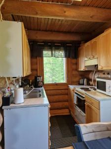 a kitchen with wooden cabinets and a white refrigerator at Vacation Home Tulikallio in Suonenjoki