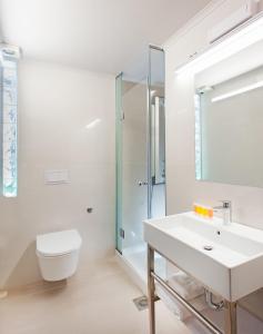 bagno con lavandino, servizi igienici e specchio di Splanzia Boutique Hotel a Chania