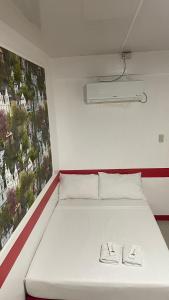 a white bed in a room with a picture on the wall at DESTINY's PLACE HOTEL CHEAPEST! COLDEST! MAGANDA! MALINIS! NEAR ROBINSONS XENTRO MALL in Calapan