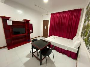 a room with a table and a red curtain at DESTINY'S PLACE HOTEL - STAY COOL THIS SUMMER! COLD ROOMS!! CHEAPEST RATE! NEAR ROBINSONs XENTRO MALL!! in Calapan