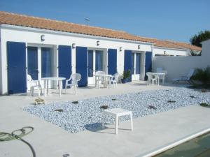 a patio with tables and chairs in front of a building at Les Mouettes in La Cotinière