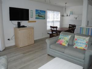 a living room with a couch and a flat screen tv at Golf Resort Villa 1503 Steps to Pool in Calabash