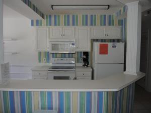 una cocina con armarios blancos y una pared a rayas en Golf Resort Villa 1503 Steps to Pool, en Calabash