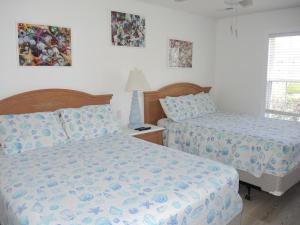 a bedroom with two beds and a lamp and a window at Golf Resort Villa 1503 Steps to Pool in Calabash +32 photos