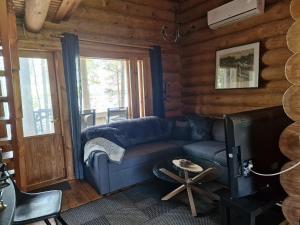 una sala de estar con un sofá azul en una cabaña de madera en Vacation Home Tulikallio, en Suonenjoki