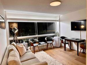 un soggiorno con divano e tavolo con sedie di Lovely refurbished 1 bed near marina + parking a Sydney