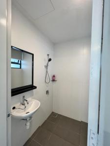 a white bathroom with a sink and a mirror at Private Residence Waterfront in Port Dickson