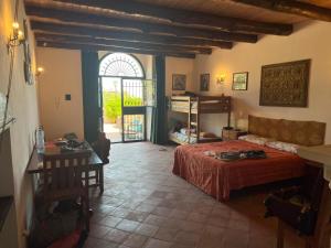 a bedroom with a bed and a table and a window at Antico Casale dell'Etna in Puntalazzo