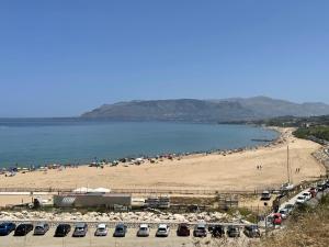 una spiaggia con un sacco di auto parcheggiate sopra di Casa Vacanza Sicilia Dolce Mare a Balestrate