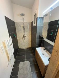 uma casa de banho com um chuveiro e um lavatório. em Danner Familien-Ferienwohnungen Schörfling am Attersee em Schörfling