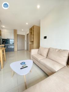 a living room with a couch and a table at It Dust Homestay 2 - The Wooden Apartment in Hanoi