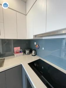 a kitchen with white cabinets and a counter top at It Dust Homestay 2 - The Wooden Apartment in Hanoi +30 photos