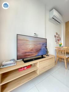 a flat screen tv sitting on top of a wooden entertainment center at It Dust Homestay 2 - The Wooden Apartment in Hanoi