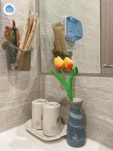 eine Theke mit zwei Tassen und eine Vase mit Blumen in der Unterkunft It Dust Homestay 2 - The Wooden Apartment in Hanoi