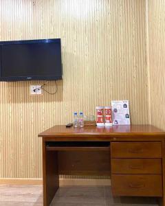 a wooden desk with a television on a wall at Hoa Sua Hotel in Vung Tau