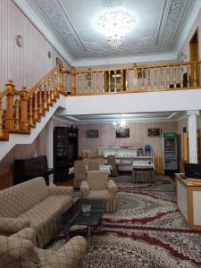 uma sala de estar com uma escada e uma sala de estar com sofás em Sulton-Sayyor em Khiva
