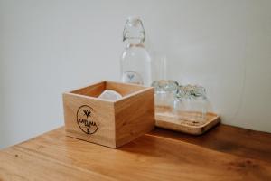 a wooden box and glasses on a table with a bottle at Kayuma House Canggu in Canggu