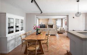 a kitchen and living room with a wooden table and chairs at Villa Flower in Sveti Lovreč Pazenatički