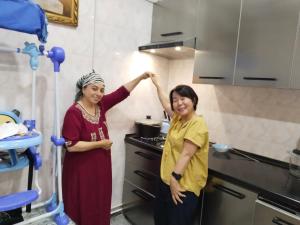 Dos mujeres están de pie en una cocina en Hotel Rizqiro'z Boutique, en Bukhara