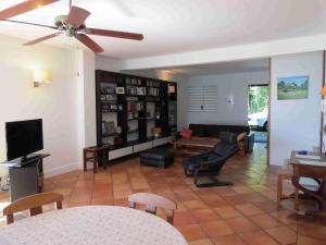 uma sala de estar com um sofá e uma televisão em Villa Bourbon avec piscine sur la plage em Saint-Gilles-les-Bains