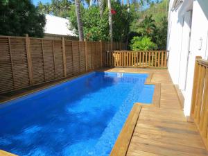 uma piscina num quintal com uma cerca de madeira em Villa Bourbon avec piscine sur la plage em Saint-Gilles-les-Bains