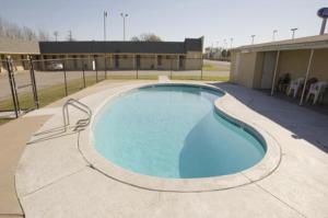 a large swimming pool in front of a building at Americas Best Value Inn Giddings in Giddings