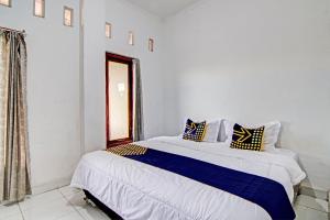 a bedroom with a large bed with blue and white sheets at SPOT ON 92914 Meranti Homestay in Pekanbaru