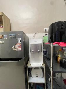 a kitchen with a coffee maker on a shelf next to a machine at Homestay Haris nearby USIM in Nilai