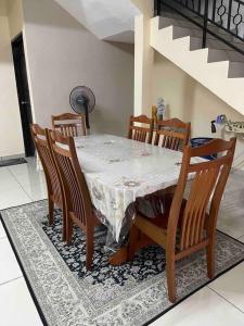 a dining room table with chairs and a white table cloth at Homestay Haris nearby USIM in Nilai