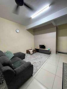 a living room with a couch and a tv at Homestay Haris nearby USIM in Nilai
