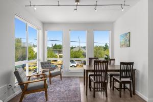 uma sala de jantar com mesa, cadeiras e janelas em Modern Luxury Home with EV Garage, Office, Bike & Balcony, WFH & Family Friendly em Seattle