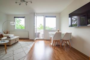 Biały salon ze stołem i krzesłami w obiekcie Exclusive 2-Room-City-Apartment - Contactless Check-in w Hanowerze