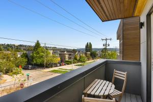 uma cadeira de madeira sentada numa varanda com vista para uma rua em Modern Luxury Home with EV Garage, Office, Bike & Balcony, WFH & Family Friendly em Seattle