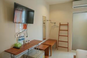 um quarto com uma secretária e uma televisão na parede em Krabi Pitta House em Cidade de Krabi