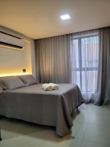 a bedroom with a bed and a large window at Excelente Flat no Bessa a 50m da praia in Tambaú +32 photos