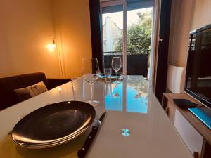 una mesa con un plato y dos copas de vino. en Serenity House, à 30 min de paris, en Grigny