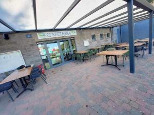 un patio vide avec des tables et des chaises dans un bâtiment dans l'établissement Au cœur de la nature, à Olloy-sur-Viroin
