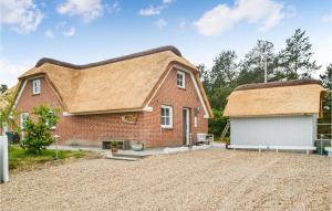 een huis met een rieten dak en een garage bij Nice Home In Oksbl With Sauna in Mosevrå
